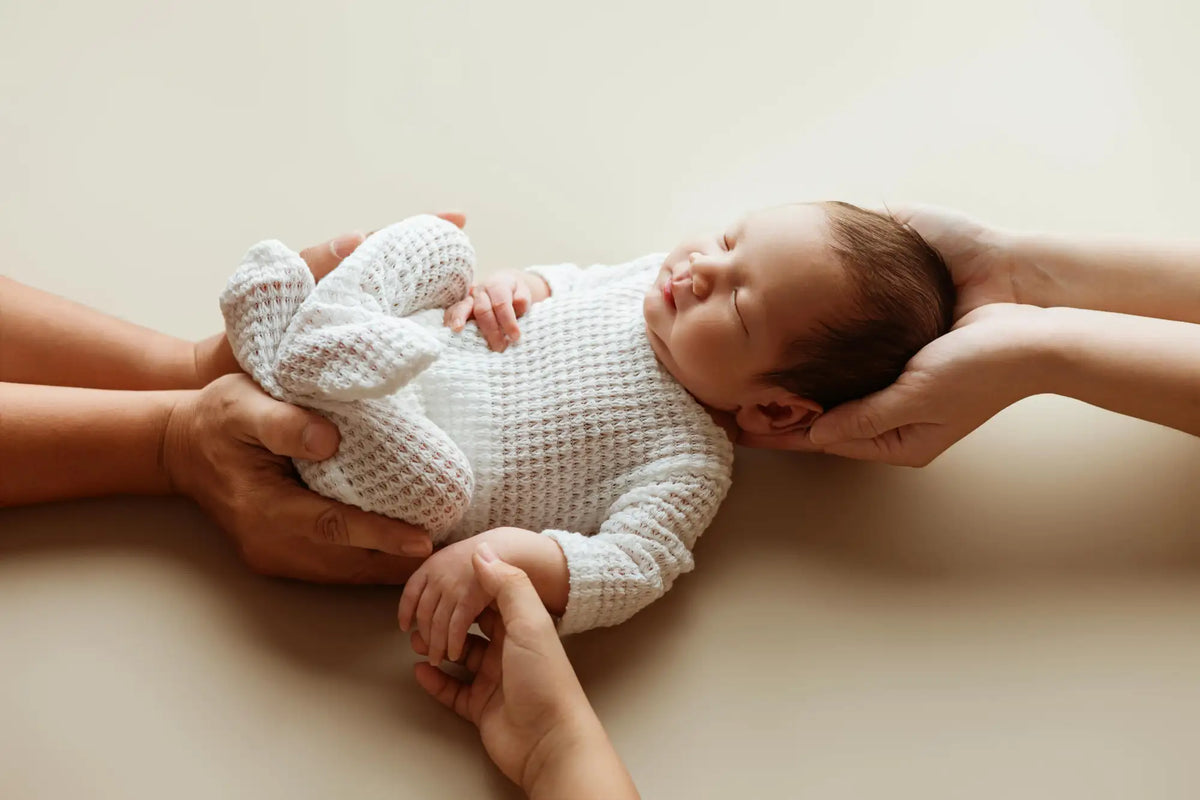 Un body de bébé doux et blanc tricoté avec un motif texturé semblable à une gaufre.