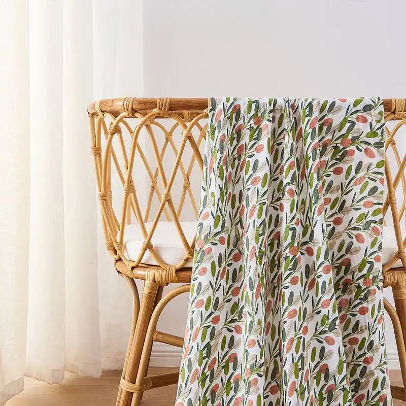 Tissu à motif floral drapé sur une chaise en rotin.