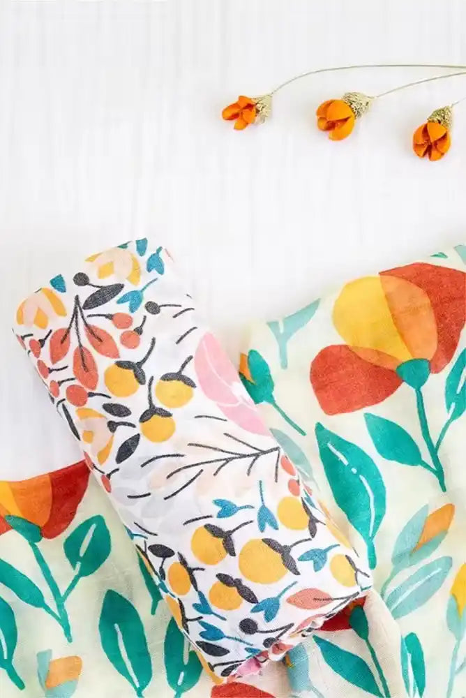 Tissu ou textile à motifs floraux avec des motifs botaniques orange, jaune et teal.