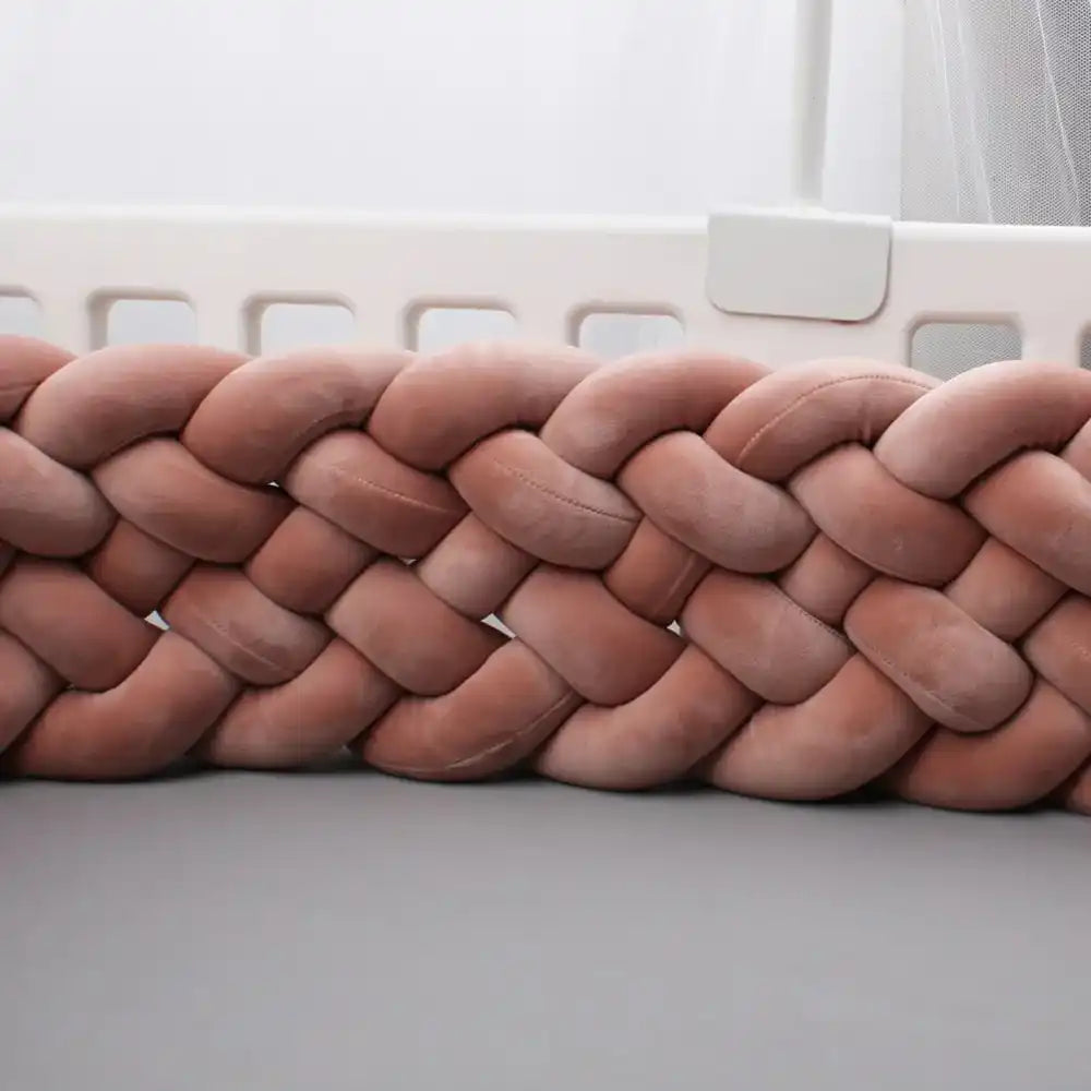 Coussin en velours rose tressé avec un motif tissé épais.